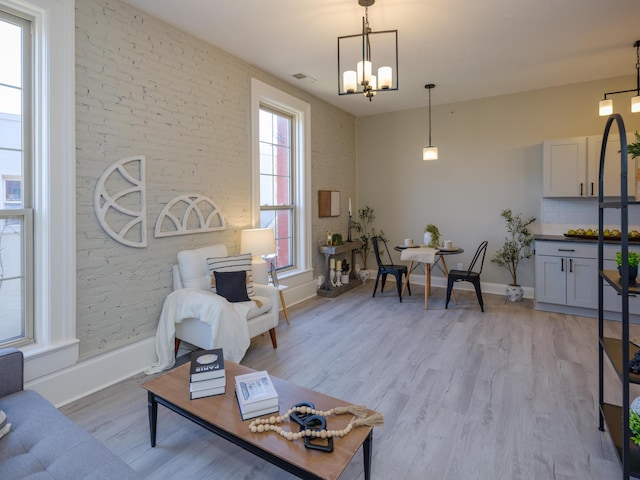 living room featuring baseboards, light wood-style flooring, and a chandelier