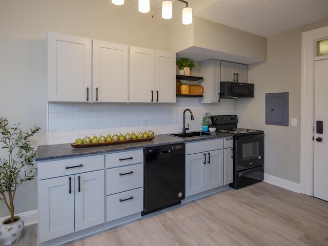 kitchen featuring open shelves, a sink, dark countertops, black appliances, and electric panel