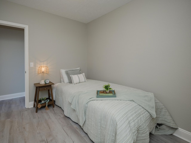 bedroom with baseboards and light wood-type flooring