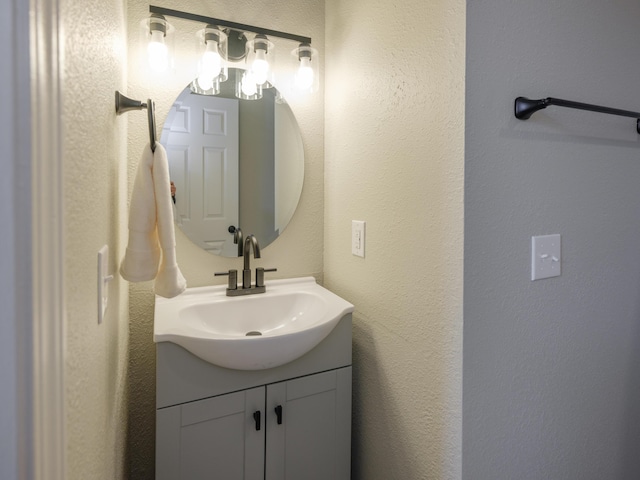 bathroom featuring vanity and a textured wall