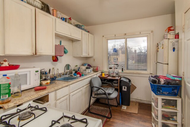 16917 Griggs St, Detroit, MI 48221 - kitchen with dark wood-type flooring, light countertops, a sink, and white appliances