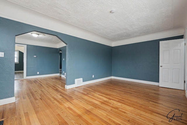 10088 Britain St, Detroit, MI 48224 - unfurnished room with wood-type flooring, arched walkways, baseboards, and visible vents