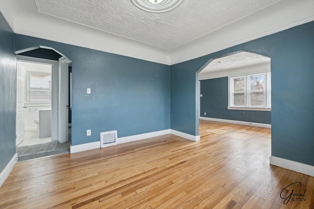 10088 Britain St, Detroit, MI 48224 - empty room featuring wood finished floors, arched walkways, baseboards, and visible vents