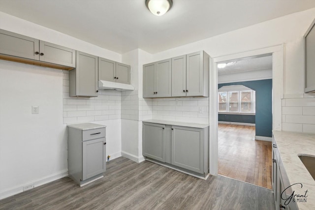 10088 Britain St, Detroit, MI 48224 - kitchen with dark wood finished floors, baseboards, gray cabinets, and decorative backsplash