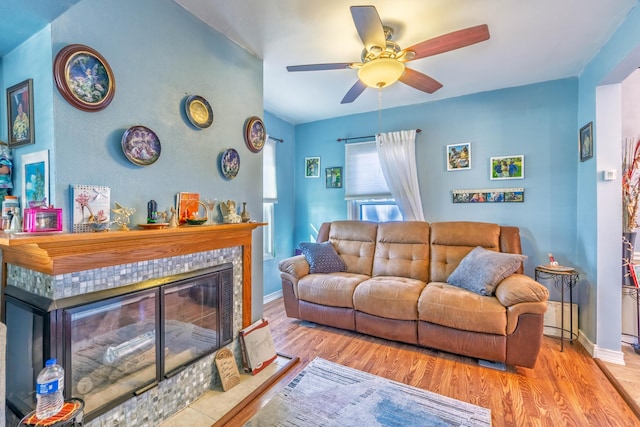 3803 Miller Rd, Kalamazoo, MI 49001 - living area with a ceiling fan, wood finished floors, a tiled fireplace, and baseboards