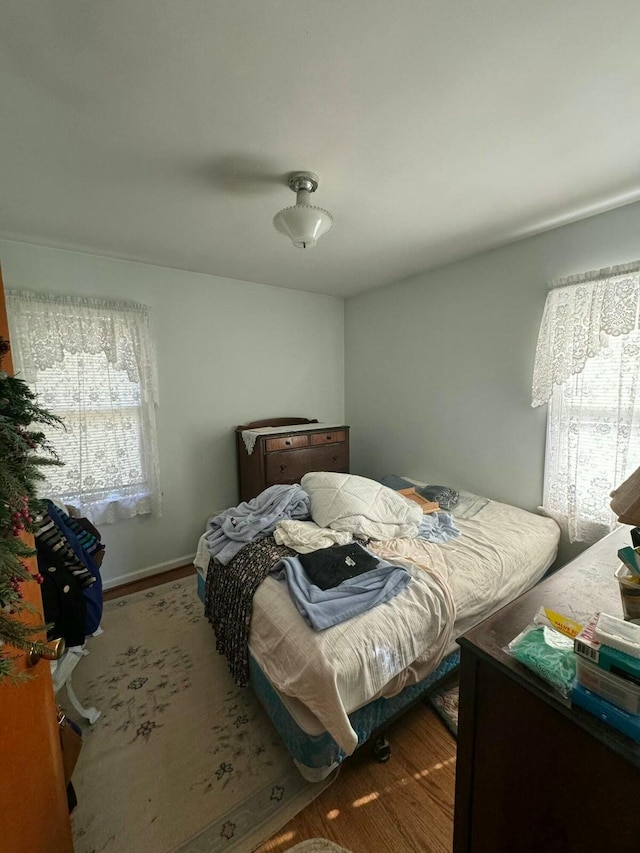 bedroom with baseboards and wood finished floors