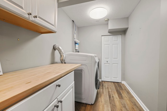 laundry area featuring baseboards, cabinet space, and dark wood-style floors