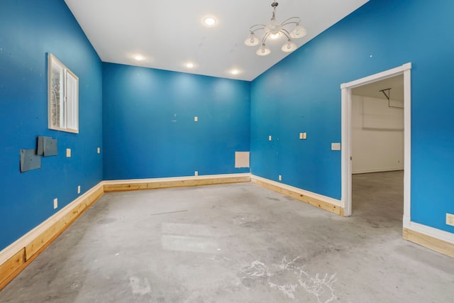 spare room with unfinished concrete floors, an inviting chandelier, baseboards, and recessed lighting
