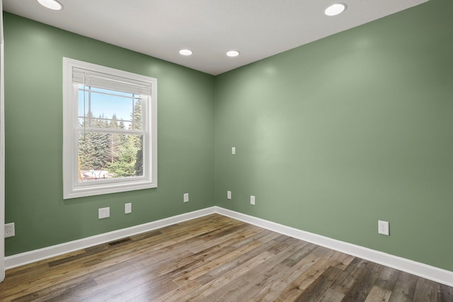 spare room featuring baseboards, visible vents, wood finished floors, and recessed lighting