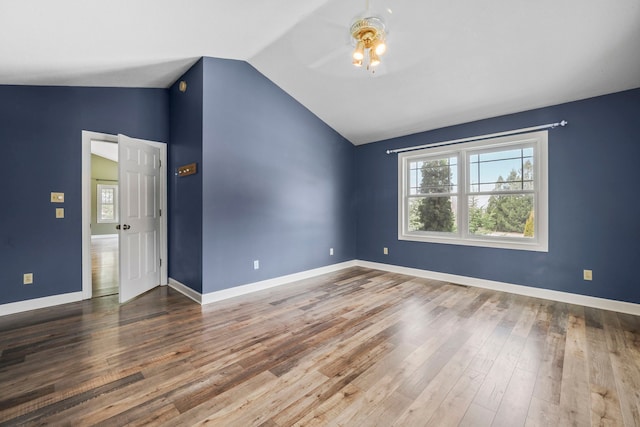 unfurnished room featuring baseboards, lofted ceiling, wood finished floors, and a ceiling fan