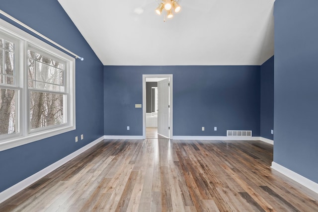 bonus room featuring hardwood / wood-style floors, lofted ceiling, visible vents, and baseboards