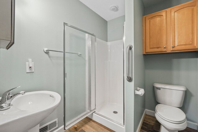 full bathroom featuring visible vents, baseboards, toilet, a sink, and a stall shower