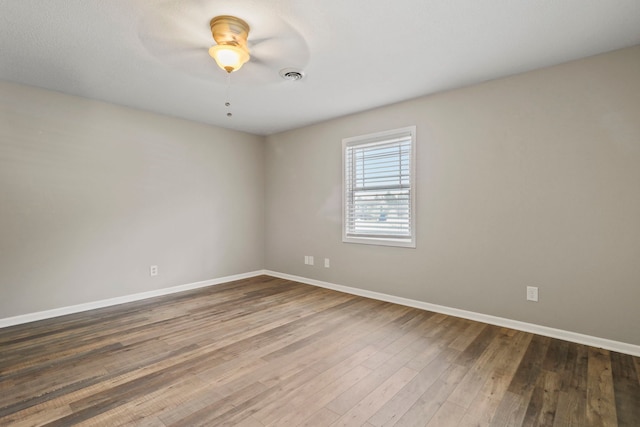 unfurnished room featuring a ceiling fan, wood finished floors, baseboards, and visible vents