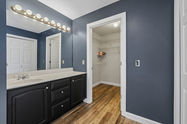 bathroom with vanity, baseboards, and wood finished floors
