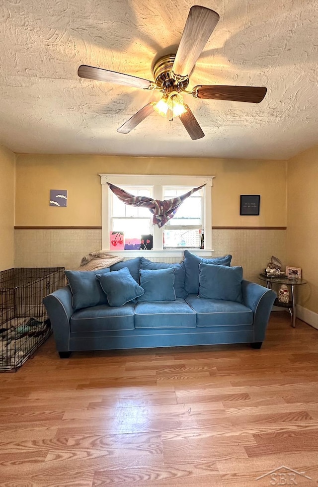 639 N Center St, Sebewaing, MI 48759 - living room featuring a textured ceiling, wood finished floors, and a wainscoted wall