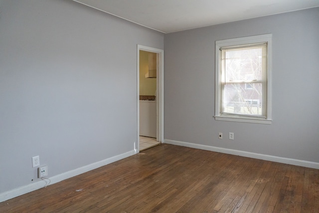 spare room featuring baseboards and wood-type flooring