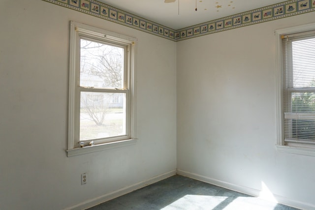 empty room with a ceiling fan and baseboards