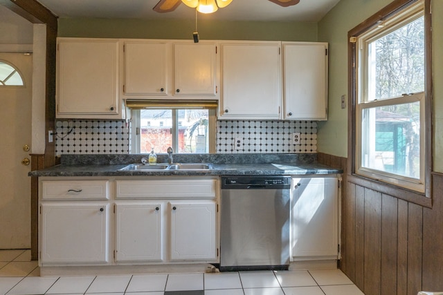 kitchen featuring white cabinets, a sink, dark countertops, and stainless steel dishwasher