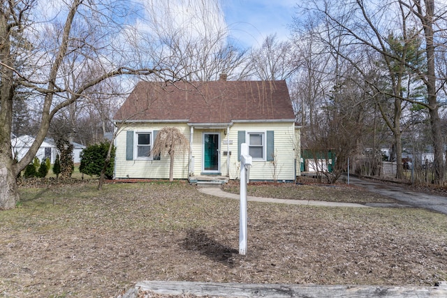 view of front of home featuring a shingled roof and a chimney