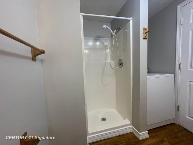 bathroom featuring a textured ceiling, wood finished floors, and a walk in shower