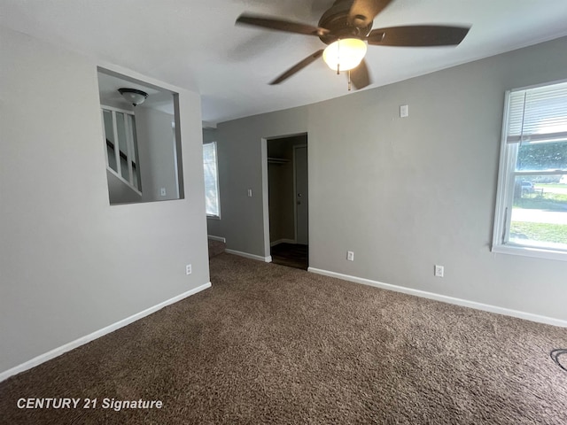 unfurnished room featuring baseboards, carpet floors, ceiling fan, and plenty of natural light