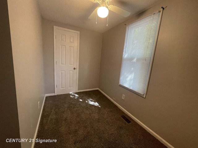 unfurnished room with baseboards, carpet, visible vents, and a ceiling fan