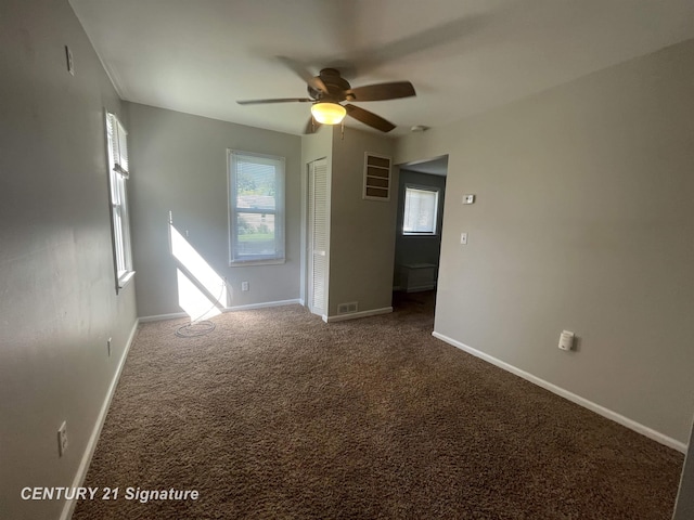 carpeted empty room featuring baseboards and ceiling fan