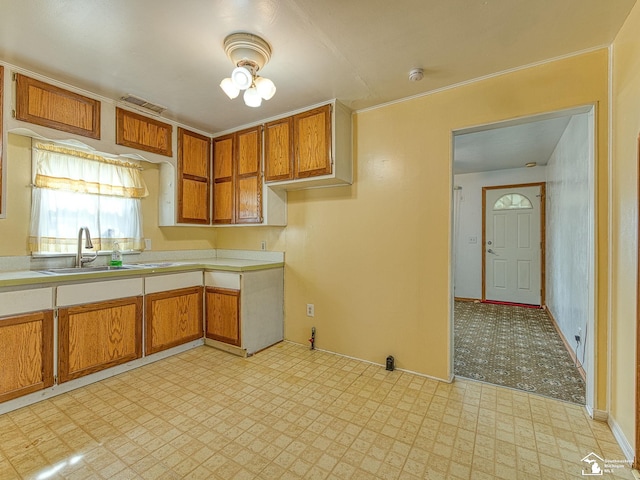20212 Northline Rd, Taylor, MI 48180 - kitchen featuring light flooring, light countertops, brown cabinetry, a sink, and ornamental molding