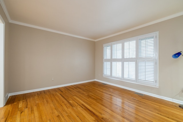 spare room featuring baseboards, visible vents, ornamental molding, and light wood-style flooring