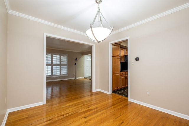 unfurnished room with baseboards, light wood-style flooring, and ornamental molding