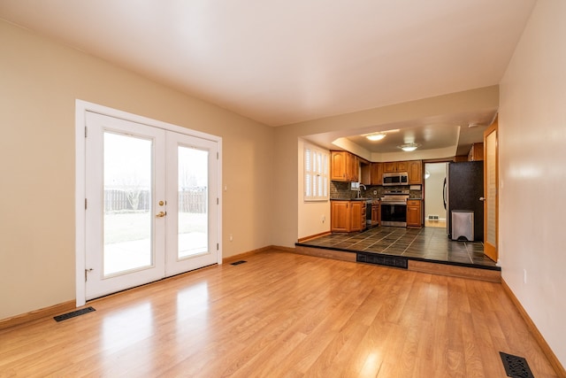 kitchen featuring visible vents, stainless steel appliances, dark countertops, a sink, and french doors