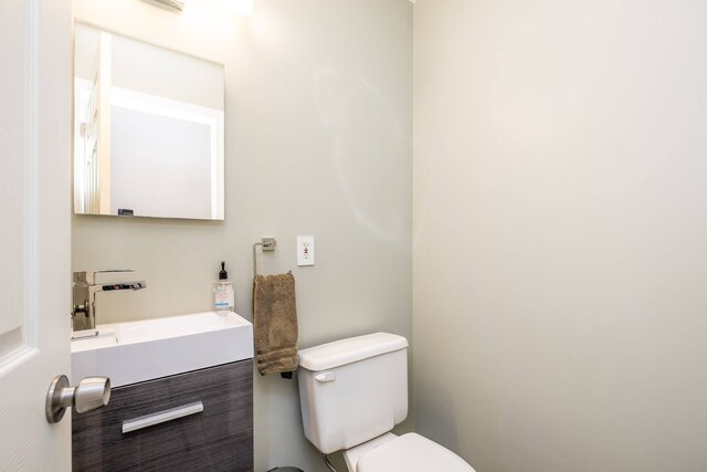 half bath featuring toilet and vanity