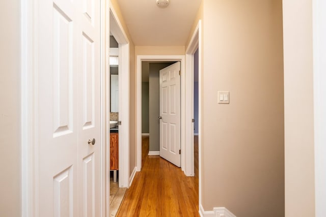 hallway with baseboards and light wood-style flooring