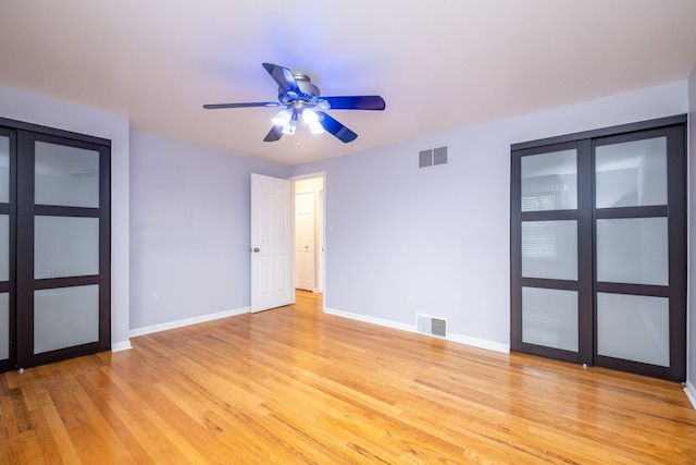 spare room featuring a ceiling fan, baseboards, light wood-style floors, and visible vents