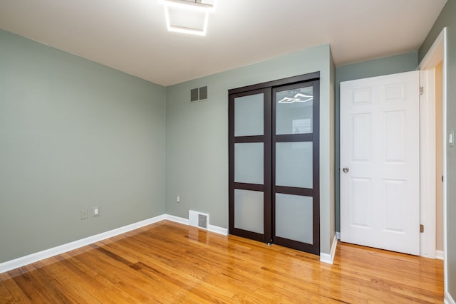 unfurnished room with baseboards, visible vents, and light wood-style floors