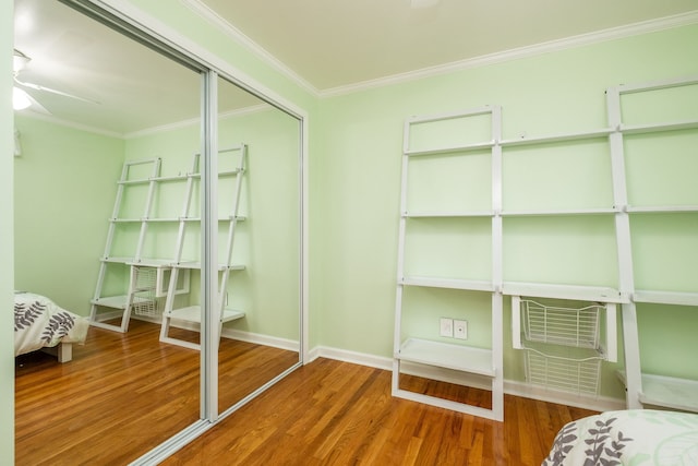 interior space featuring ornamental molding, baseboards, a closet, and wood finished floors