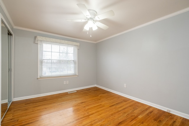 unfurnished bedroom with a closet, visible vents, light wood-style floors, and crown molding