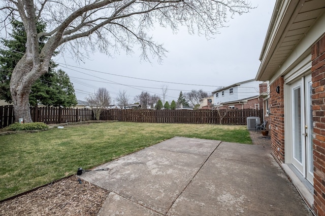 view of yard with central air condition unit, a fenced backyard, and a patio