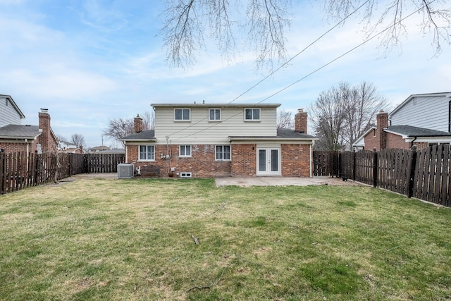 back of property with central AC unit, a chimney, a patio area, and french doors