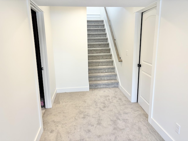 stairs featuring carpet flooring and baseboards