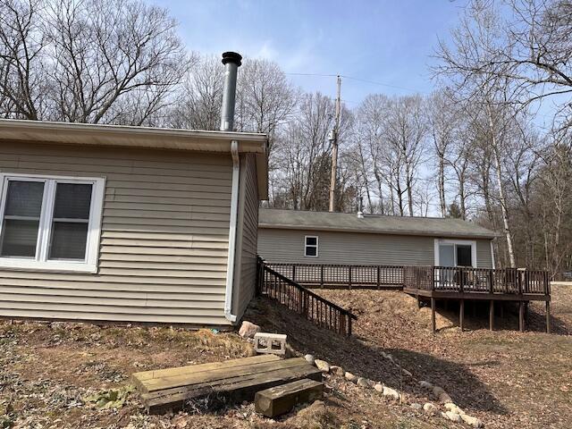 8034 N Johnson Rd, Irons, MI 49644 - view of property exterior featuring stairway and a wooden deck