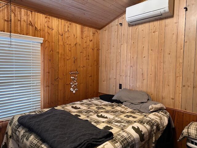8034 N Johnson Rd, Irons, MI 49644 - bedroom featuring vaulted ceiling, wood walls, an AC wall unit, and wooden ceiling