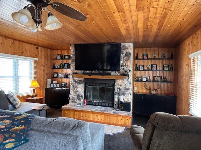 8034 N Johnson Rd, Irons, MI 49644 - living area featuring a ceiling fan, wood ceiling, wood walls, and a fireplace