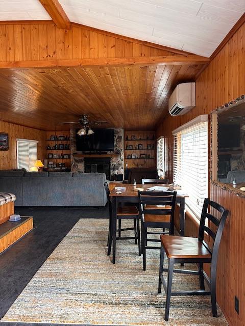 8034 N Johnson Rd, Irons, MI 49644 - dining area featuring a wall unit AC, wood walls, vaulted ceiling, and ceiling fan