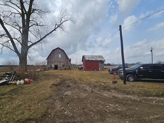 view of yard with driveway, an outdoor structure, and a barn
