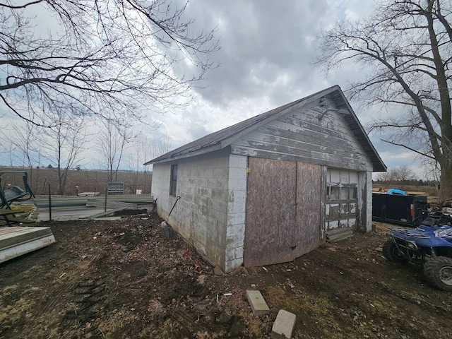view of side of property with an outbuilding and concrete block siding