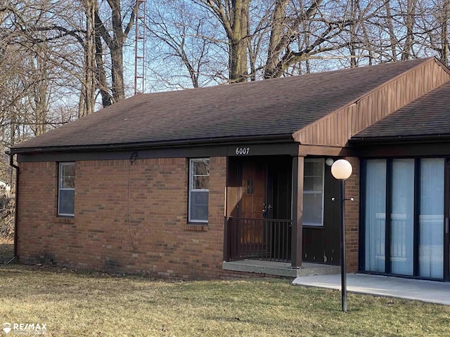 6007 Corunna Rd, Flint, MI 48532 - view of front of property with roof with shingles, brick siding, and a front yard