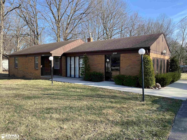 6007 Corunna Rd, Flint, MI 48532 - ranch-style home with a chimney, brick siding, a front yard, and roof with shingles