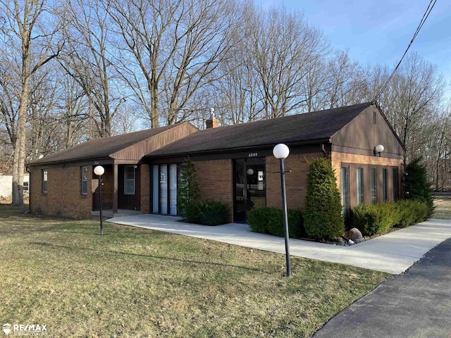 6007 Corunna Rd, Flint, MI 48532 - view of front of home featuring a front yard, a chimney, brick siding, and roof with shingles