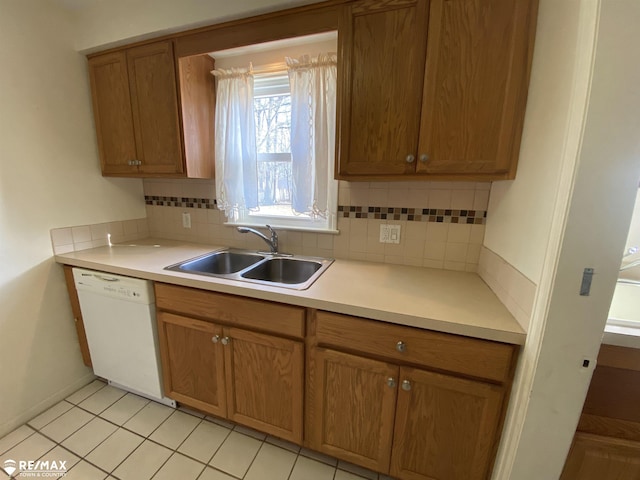 6007 Corunna Rd, Flint, MI 48532 - kitchen featuring white dishwasher, a sink, tasteful backsplash, light countertops, and brown cabinets